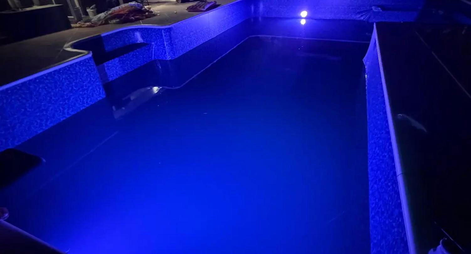 Color LED pool lighting under test at night after commissioning