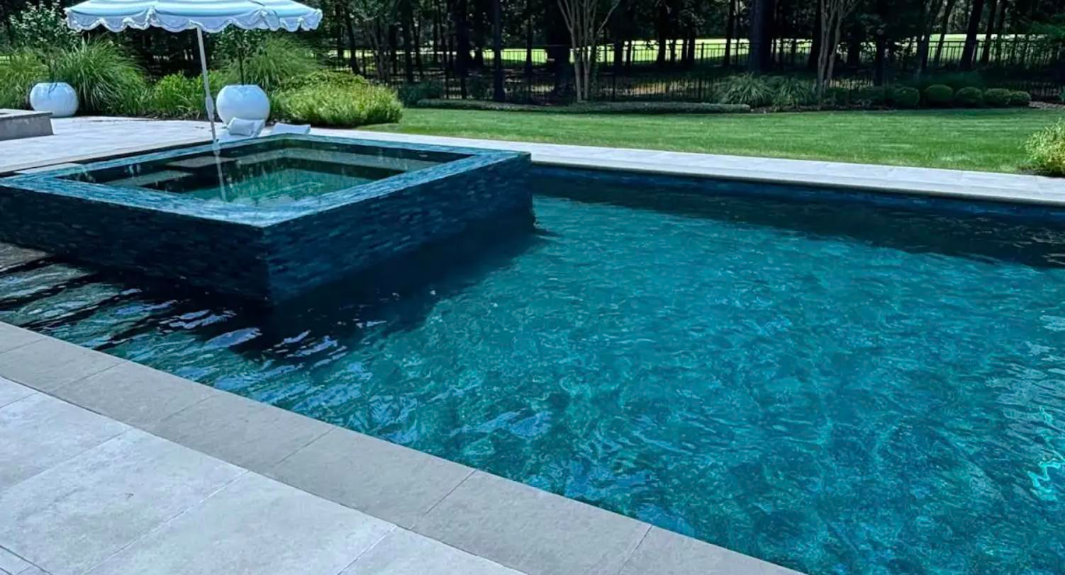 Finished custom pool with raised spa and spillway, clear balanced water