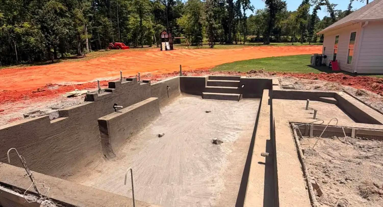 Cured gunite pool shell with bench, steps and spa footprint before tile and coping