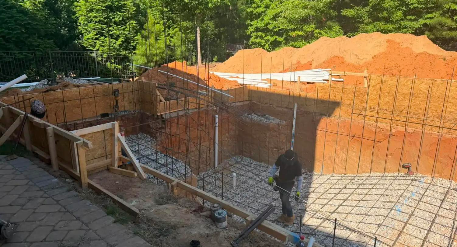 Engineered shoring and reinforcing steel cage set in a pool excavation before shotcrete